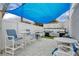 Outdoor grilling area with multiple grills, dining tables, and shade under a blue canopy at 5207 S Atlantic Ave # 225, New Smyrna Beach, FL 32169
