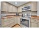 Kitchen featuring stainless steel appliances, granite countertops, and tan cabinetry at 5207 S Atlantic Ave # 225, New Smyrna Beach, FL 32169