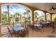 Outdoor dining area with metal tables and chairs overlooking the pool and tropical landscaping at 528 Terra Lago St, Davenport, FL 33897