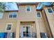 Rear exterior view of a tan two-story townhouse with covered patio area at 528 Terra Lago St, Davenport, FL 33897
