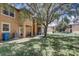 Townhome exterior with a green lawn, patio, and mature trees creating a shaded area at 528 Terra Lago St, Davenport, FL 33897