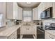 Well-lit kitchen featuring white cabinetry, stainless steel appliances, and stylish backsplash, offering a modern and efficient workspace at 528 Terra Lago St, Davenport, FL 33897
