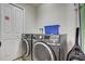 Modern laundry room with front loading washer and dryer units, plus added storage at 528 Terra Lago St, Davenport, FL 33897