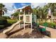 Playground with a slide, tic-tac-toe board and steps surrounded by palm trees and greenery at 528 Terra Lago St, Davenport, FL 33897
