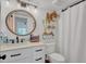 Bathroom featuring a round mirror, white cabinetry, and neutral decor at 5635 Blue Shadows Ct # 3, Orlando, FL 32811