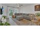 Cozy living room with a large sectional sofa, lots of plants, and natural light from the windows at 5635 Blue Shadows Ct # 3, Orlando, FL 32811