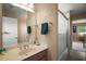 Cozy bathroom features a vanity with sink, large mirror, and a shower-tub combination with glass doors at 5683 Bassett Pl, Sanford, FL 32771