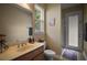 Well-lit bathroom featuring a vanity with sink, toilet, and access to shower, complemented by a patterned rug at 5683 Bassett Pl, Sanford, FL 32771
