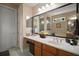 Large bathroom vanity with double sinks and decorative lighting and mirrors, adjacent to the soaking tub at 5683 Bassett Pl, Sanford, FL 32771