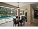 Bright dining area with serene pool views, tiled floors, and an outdoor patio at 5683 Bassett Pl, Sanford, FL 32771