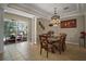 An elegant dining room with natural light, tile floors, and an ornate chandelier above the glass-top table at 5683 Bassett Pl, Sanford, FL 32771