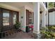 Inviting front porch with decorative columns, a seating area, lush plants, and a charming entrance at 5683 Bassett Pl, Sanford, FL 32771
