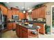 A spacious kitchen with custom wood cabinets, mosaic backsplash, granite countertops, and an island with a sink at 5683 Bassett Pl, Sanford, FL 32771