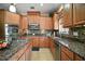The kitchen features stainless steel appliances, granite countertops, mosaic backsplash, and custom cabinets at 5683 Bassett Pl, Sanford, FL 32771
