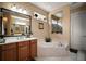Bathroom featuring a marble garden tub, and sinks and a large window at 5683 Bassett Pl, Sanford, FL 32771