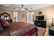 This main bedroom features a decorative ceiling fan, a large television, and access to the main bathroom at 5683 Bassett Pl, Sanford, FL 32771