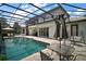 Backyard pool featuring a screened enclosure, patio seating, and manicured landscaping at 5683 Bassett Pl, Sanford, FL 32771