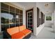 Inviting front porch with bright orange cushioned seating, complemented by dark wood accents and natural light at 5683 Bassett Pl, Sanford, FL 32771