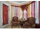 Bright sitting area features lots of light, decorative curtains, and comfortable floral chairs for reading or relaxation at 5683 Bassett Pl, Sanford, FL 32771