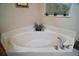Corner soaking tub accented with marble surround and faucet fixtures with a garden window at 5683 Bassett Pl, Sanford, FL 32771
