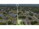 An aerial view showcases a home in a neighborhood with mature trees, a pond, and well-maintained lawns at 7469 Hunters Greene Cir, Lakeland, FL 33810