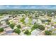 An aerial view showcases a neighborhood with a central pond and well-maintained lawns with mature landscaping at 7469 Hunters Greene Cir, Lakeland, FL 33810