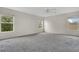 Large bedroom features neutral carpeting, ceiling fan, and natural light from three windows at 7469 Hunters Greene Cir, Lakeland, FL 33810