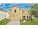 Two-story home featuring an attached two-car garage and well-maintained lawn at 7469 Hunters Greene Cir, Lakeland, FL 33810