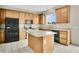 Functional kitchen featuring light wooden cabinets, black appliances, and a center island at 7469 Hunters Greene Cir, Lakeland, FL 33810
