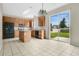 Well-lit kitchen with tile floor, an island, wood cabinets, and black appliances, opening to a yard through a sliding glass door at 7469 Hunters Greene Cir, Lakeland, FL 33810