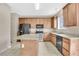 Functional kitchen featuring light wooden cabinets, black appliances, and a granite center island at 7469 Hunters Greene Cir, Lakeland, FL 33810