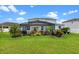 Well-maintained backyard features a screened-in patio, lush green lawn, and colorful, tropical landscaping at 816 Carmillion Ct, Groveland, FL 34736