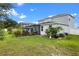 An expansive green lawn in the backyard features a screened patio, landscaping, and a light-blue two-story home at 816 Carmillion Ct, Groveland, FL 34736