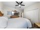 This bedroom includes a ceiling fan, large dresser, and a closet with sliding doors at 816 Carmillion Ct, Groveland, FL 34736