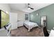 Modern bedroom features green accent wall, tv, white dresser, and neutral carpet at 816 Carmillion Ct, Groveland, FL 34736