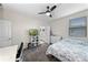 Bedroom features a ceiling fan, tv, desk and chair, and a white dresser at 816 Carmillion Ct, Groveland, FL 34736
