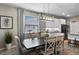Charming dining area featuring a modern light fixture, a dark wood table and kitchen view at 816 Carmillion Ct, Groveland, FL 34736