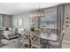 An elegant dining area is shown with a modern chandelier and gray color scheme at 816 Carmillion Ct, Groveland, FL 34736