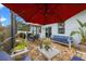 Screened patio area with a large umbrella, comfortable seating, an outdoor dining table and barbecue at 816 Carmillion Ct, Groveland, FL 34736