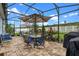 Enjoy this screened patio featuring stylish furniture, a barbecue, and views of the backyard at 816 Carmillion Ct, Groveland, FL 34736