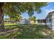 Spacious backyard with lush greenery, featuring a shed, a covered patio, and mature trees at 911 Ursula St, Ocoee, FL 34761