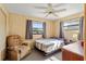 Comfortable bedroom featuring natural light, fan, neutral decor, and an accent chair at 911 Ursula St, Ocoee, FL 34761