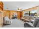 Spacious living room with wood paneling, neutral carpeting, and ample seating at 911 Ursula St, Ocoee, FL 34761