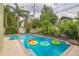 Lush backyard with a sparkling pool and colorful floats surrounded by tropical plants at 1012 W New Hampshire St, Orlando, FL 32804