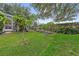 Spacious backyard features a lush lawn, mature trees, and a screened-in lanai in the distance at 10146 Pointview Ct, Orlando, FL 32836