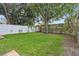 Lush green backyard featuring a mature tree and partially fenced border, with a brick planter visible at 10146 Pointview Ct, Orlando, FL 32836