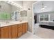 Bright bathroom with double vanity sinks and a view into the bedroom at 10146 Pointview Ct, Orlando, FL 32836