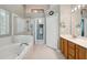 Spacious bathroom featuring a soaking tub, glass shower, and vanity with ample counter space at 10146 Pointview Ct, Orlando, FL 32836