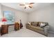 Inviting bedroom with a comfortable sofa, desk, and natural light from a window at 10146 Pointview Ct, Orlando, FL 32836