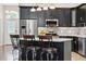 Kitchen island with bar stool seating overlooking stainless steel appliances and contemporary cabinetry at 10146 Pointview Ct, Orlando, FL 32836